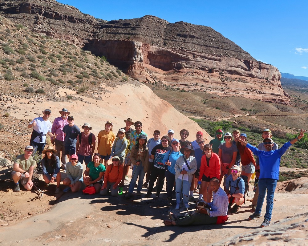 Graduate students standing on desert rock