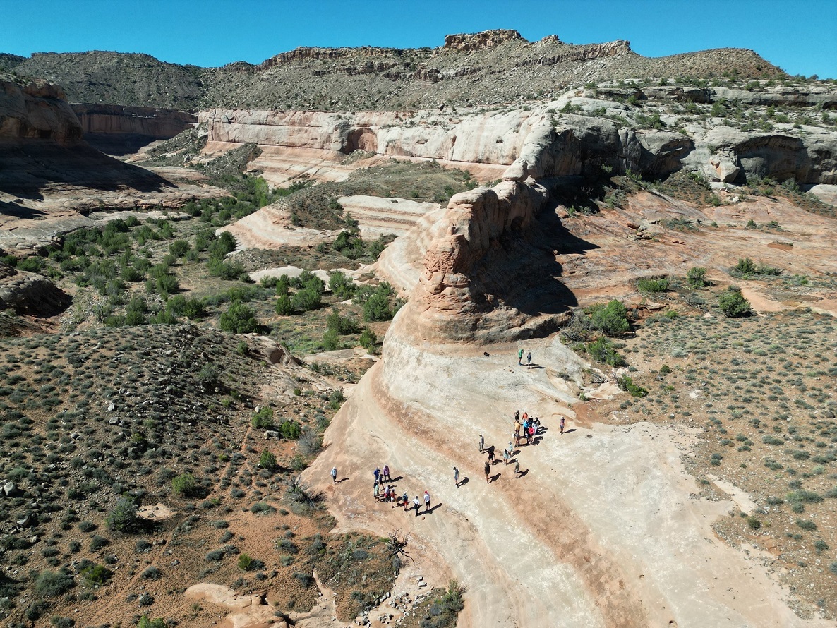 Drone shot of graduate students standing on desert rock