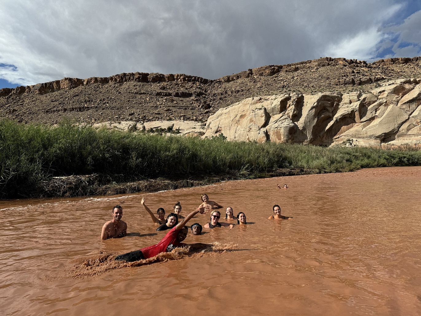 Graduate students swimming in muddy river