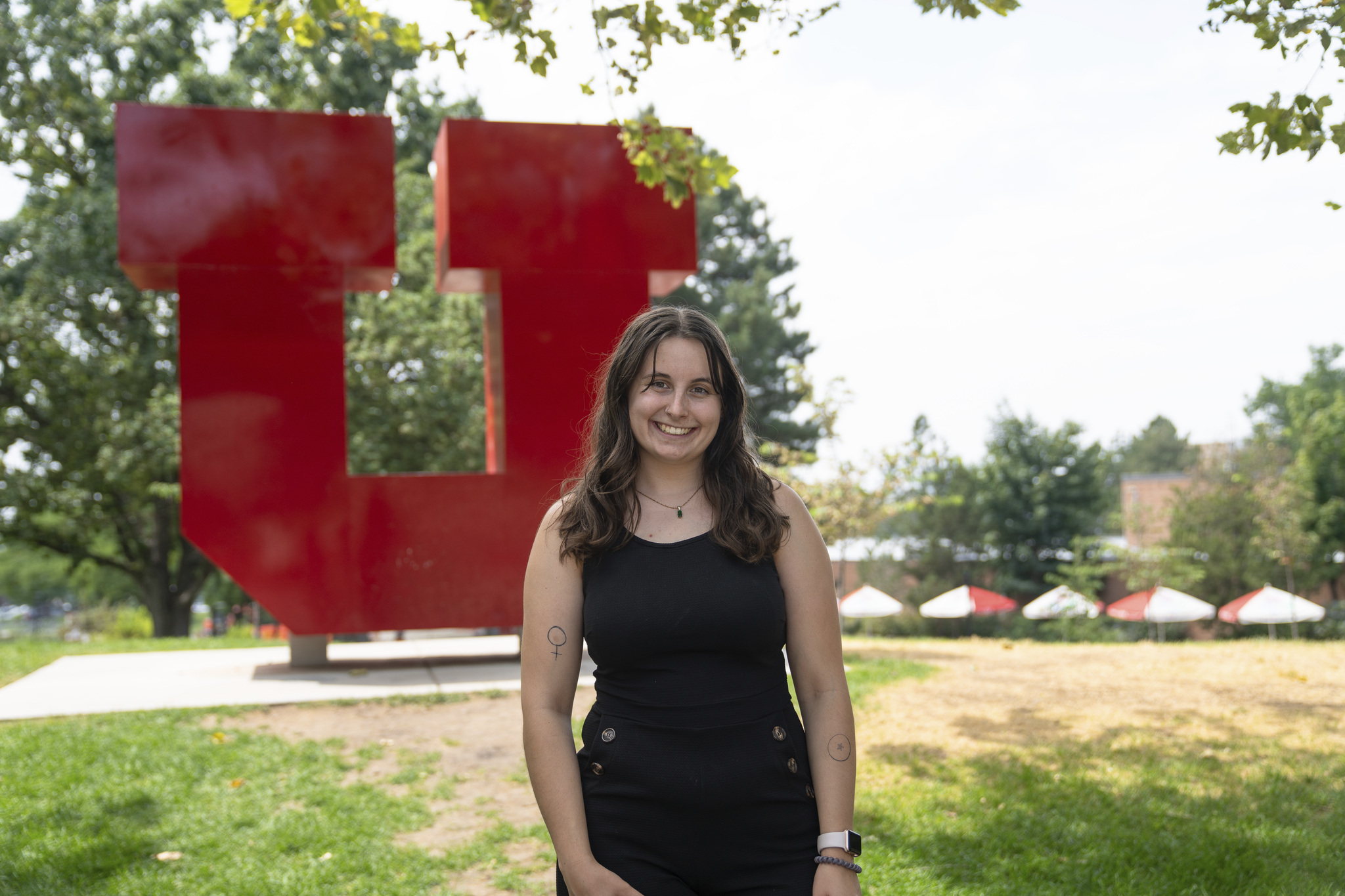 Student stands in front of red block U 